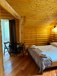 - une chambre avec un lit et une table dans une cabine dans l'établissement Явір Резорт, à Starychi