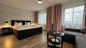 Habitación de hotel con cama y sofá en Hotel Wernerwald, en Cuxhaven