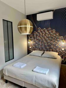 a bedroom with a large bed with two towels on it at Maison Fitzgerald in Vichy