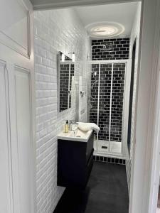 a white bathroom with a sink and a mirror at Maison Fitzgerald in Vichy +17 photos
