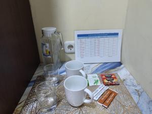 een tafel met twee koffiekopjes en een monitor bij H.V HOTEL BANDARA in Gorontalo