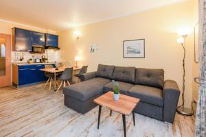 a living room with a couch and a table at Aquarius Ferienwohnung Usedom in Loddin