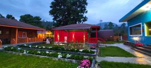 a house with a red tent in the yard at The Laughing Woods AC Resort in Kotagiri