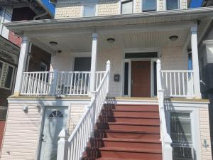 a house with a staircase leading to the front door at 4 Bedroom Few Blocks From Beach , Tropicana Casino , Stockton University , Bay in Atlantic City