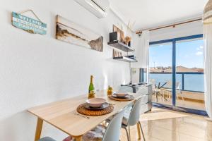 a dining room with a table and chairs with a view of the ocean at Apartamento Mandarín Playamarina 2 in Orihuela +11 photos