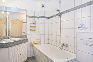 a white bathroom with a tub and a sink at Aquarius Ferienwohnung Usedom in Loddin +10 photos