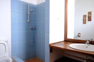 a blue tiled bathroom with a sink and a shower at Villa de Palma a Ribeira D.Joao in Figueira da Horta
