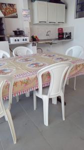 a table with two chairs and a tablecloth on it at Hostel Pé na praia - Quartos e Barracas Camping in Caraguatatuba