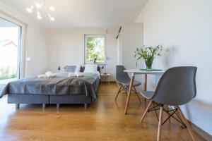 a bedroom with a bed and a table with chairs at Verde House in Karwia