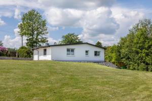 a white house on top of a grassy field at Ferienhaus Bornwiese in Schwalmtal