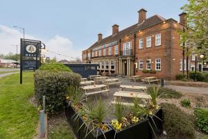 un bâtiment avec des tables et des bancs devant lui dans l'établissement Blue Bell Lodge Hotel, à Middlesbrough