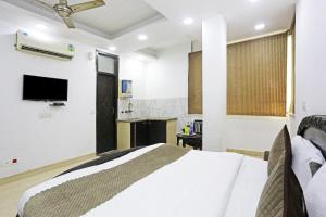 a bedroom with a bed and a tv in it at Hotel Premium Room Near Hazrat Nizamuddin railway station in New Delhi