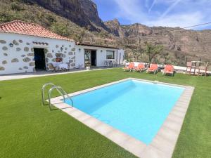 eine Villa mit Swimmingpool und ein Haus in der Unterkunft Vivelorural Abuela María 2, a place for families in San Bartolomé de Tirajana