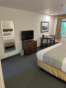 Habitación de hotel con cama, mesa y espejo en Villa Motel at Manitou Springs, en Manitou Springs
