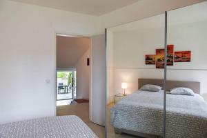 a bedroom with a bed and a mirrored wall at Casa Golf Ranch App 8000 in Ascona
