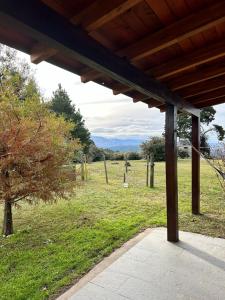 a wooden porch with a view of a field at La Azotea cabañas & suites in La Cumbrecita