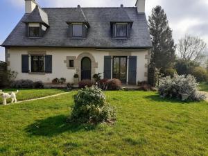 un chien debout devant une maison dans l'établissement Chambres chez l habitant, à Langrolay