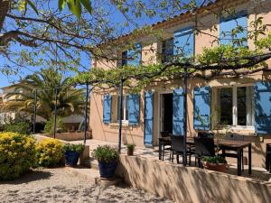 a house with chairs and a table in front of it at Villa 4 Etoiles Climatisée, Piscine, Parking in Saint-Cyr-sur-Mer