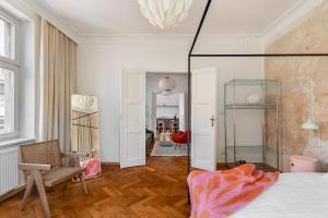 a room with a bed and a chair and a mirror at St Florian Apartments in Kraków +93 photos