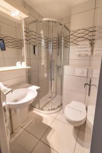 W łazience znajduje się prysznic, toaleta i umywalka. w obiekcie Kyriad Auxerre Appoigny w mieście Appoigny