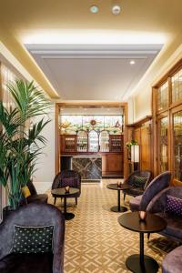 um átrio com sofás e mesas e uma lareira em Hotel Royal em De Panne
