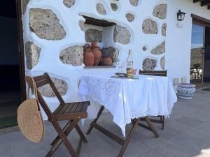 サン・バルトロメにあるVivelorural Abuela María 3, garden & poolのテーブル(椅子2脚付)とワイン1本
