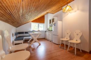 a kitchen with white chairs and a table and a refrigerator at Birutės Vila in Palanga