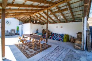 a patio with a wooden table and chairs in a room at Tulipános Porta in Sarud