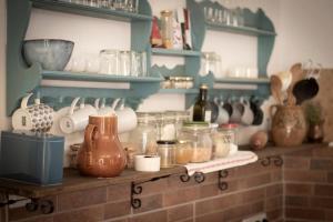 a shelf filled with lots of glass jars and bottles at Tulipános Porta in Sarud