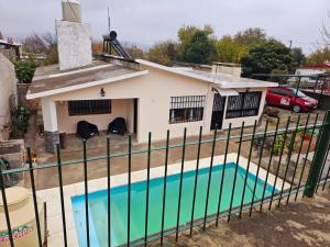 a house with a swimming pool behind a fence at LUSANYUN 1 in Villa Independencia