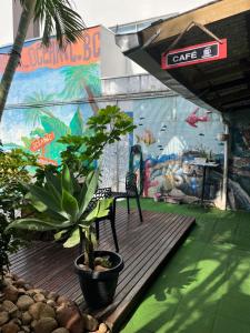 un banco sentado en una terraza de madera frente a un mural en Oceanic Hostel, en Balneário Camboriú