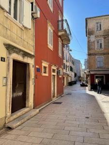 uma rua vazia numa cidade com edifícios em M&A Apartments em Zadar