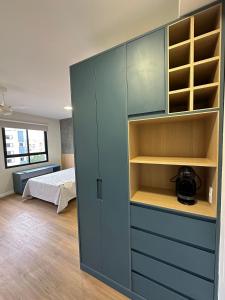 uma sala com um armário azul e um quarto em TrevizZo N.urban Pinheiros em São Paulo