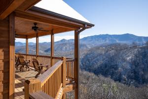 a porch of a cabin with chairs and a view of mountains at The Bear and Trout by Stony Brook Cabins in Gatlinburg