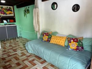 a living room with a green couch with pillows on it at Cabana Bacalar in Bacalar