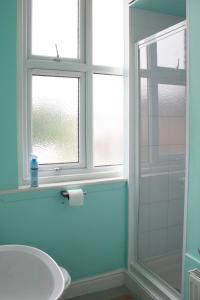 uma casa de banho com um lavatório, uma janela e um chuveiro em Landguard House Bed Only em Southampton