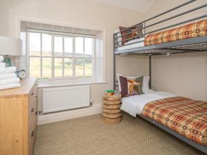 1 dormitorio con litera y ventana en 4 Bed in North York Moors National Park 75301, en Rosedale Abbey