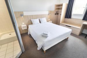 a bedroom with a white bed and a bath tub at Kyriad Direct Auxerre - Appoigny in Appoigny