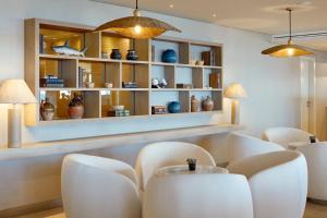 a dining room with white chairs and a table at Dom Jose Beach Hotel (Plus) in Quarteira