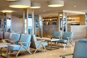 a restaurant with blue chairs and a bar at Dom Jose Beach Hotel (Plus) in Quarteira