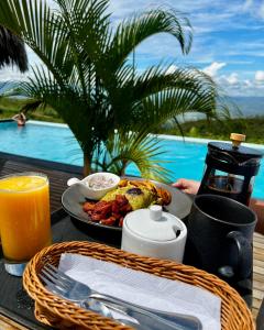 a breakfast table with a plate of food and a drink at El Resort de Yanashpa - Tarapoto in Tarapoto
