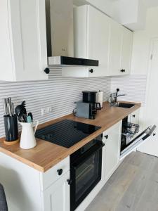 uma cozinha com armários brancos e um balcão de madeira em Apartment Sundowner em Timmendorfer Strand