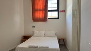 a small room with a bed and a window at Ostello di Vicenza in Vicenza
