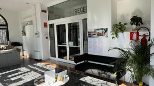 a lobby with a black couch and a window at Ostello di Vicenza in Vicenza