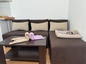 a brown couch with two towels on a table at Villa Happy Family!!! in Prijevor