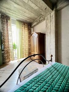una camera con letto verde in una stanza con finestra di T2&T3 Apartments LEVANTO a Tbilisi City