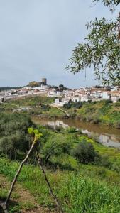 a river with a town in the background at Eleven Castelo in Mértola