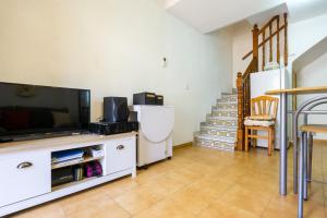 un salon avec une télévision et un escalier dans l'établissement rentafive - Bungalow - Terraza - 5 min Gran Playa, à Santa Pola