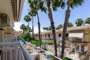 - une vue depuis le balcon d'un complexe avec des palmiers dans l'établissement rentafive - Bungalow - Terraza - 5 min Gran Playa, à Santa Pola