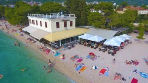 una vista aerea di una spiaggia con persone sulla sabbia di Beach rooms Riviera - Žuta Kuća a Makarska